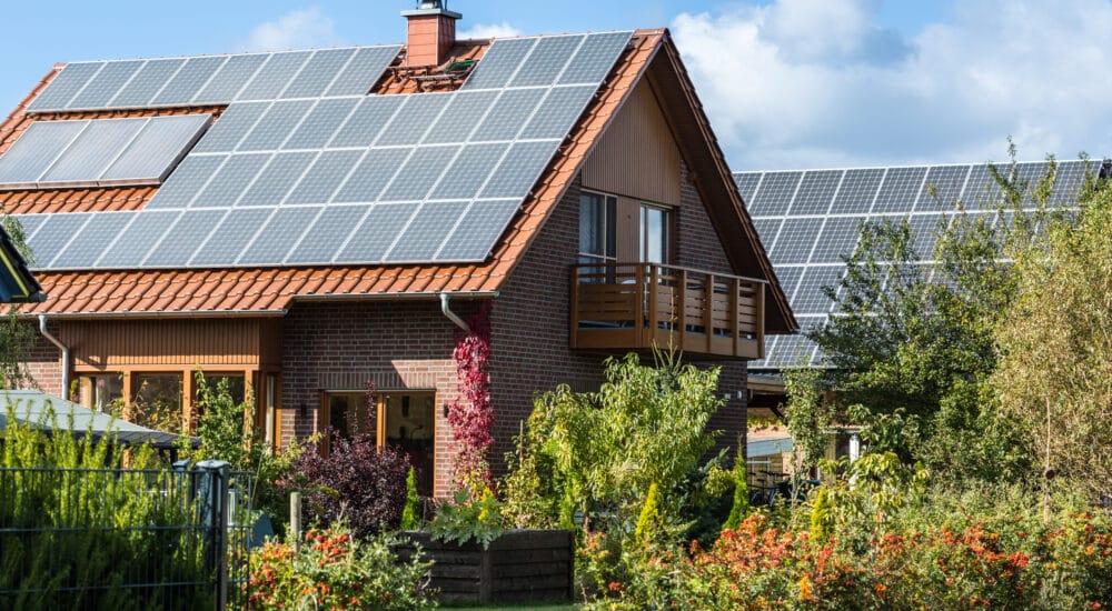 Hus med solpaneler och grön trädgård